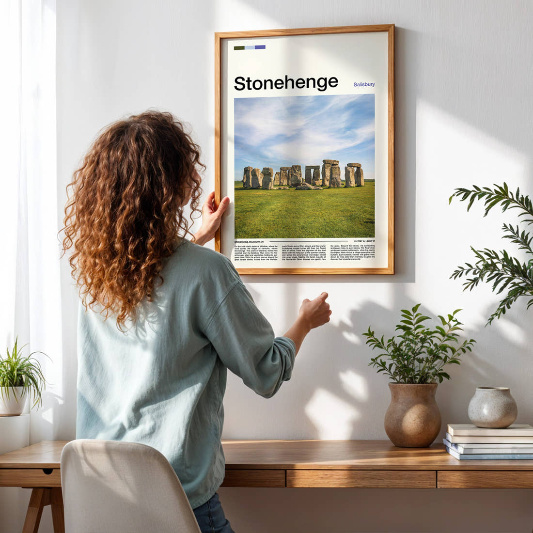 Stonehenge Ancient Standing Stones Travel Print framed on a pale wall beside houseplants
