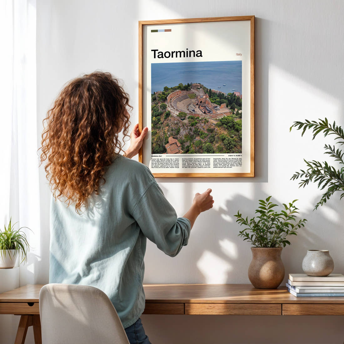 Taormina Ancient Amphitheatre Aerial Travel Print framed on a pale wall beside houseplants