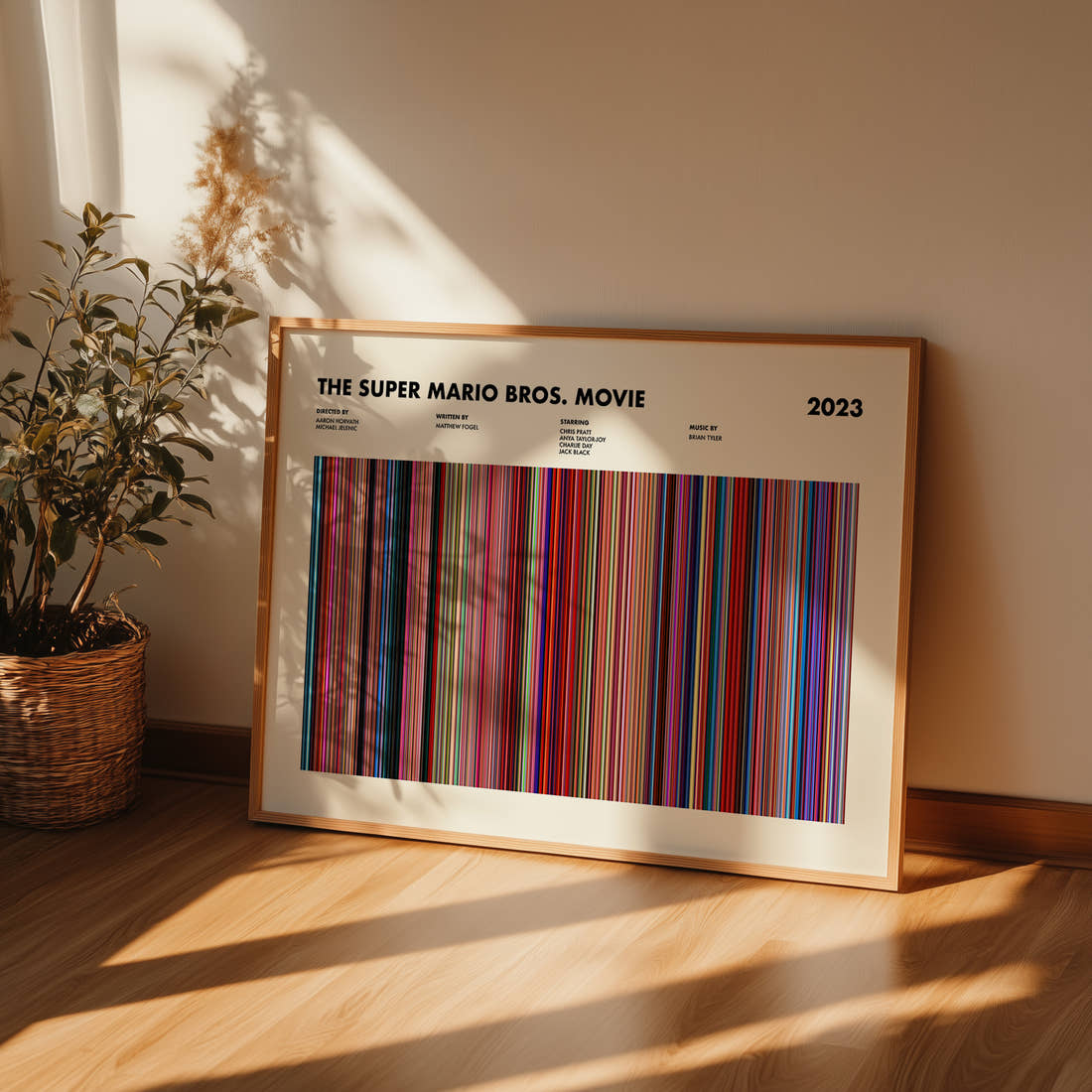 The Super Mario Bros. Movie Movie Barcode Poster framed and leaning against a wall on a wooden floor