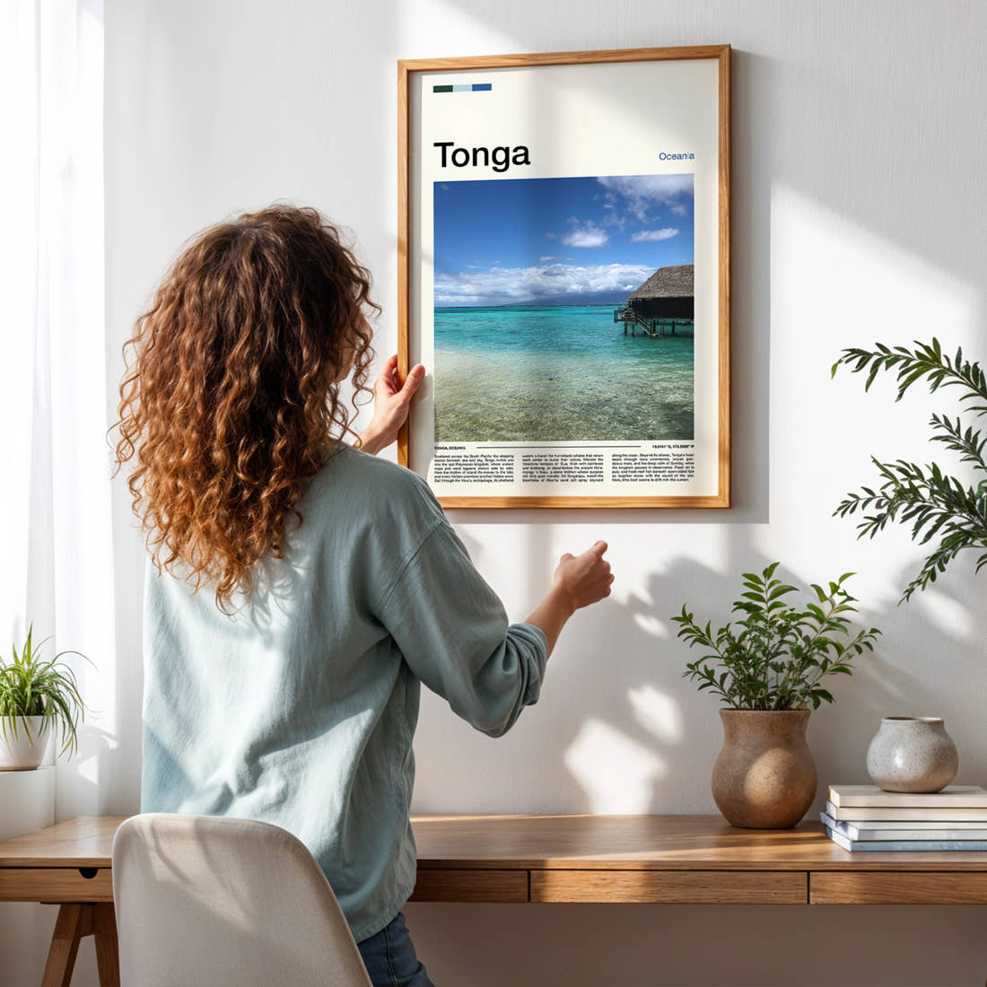 Tonga Overwater Bungalow, Lagoon Travel Print framed on a pale wall beside houseplants