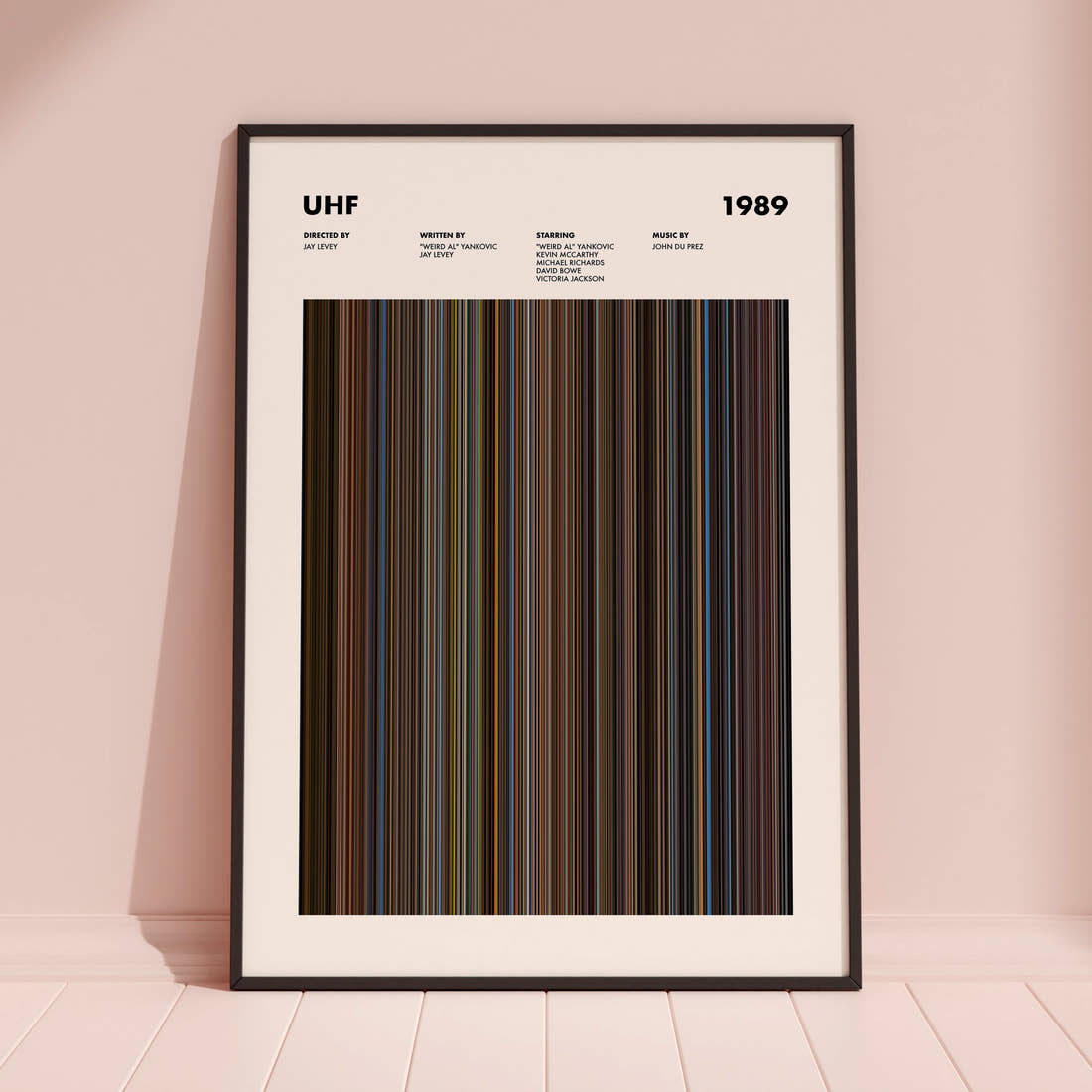UHF Movie Barcode Poster framed and leaning against a coloured wall